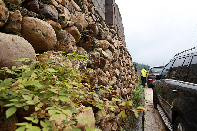 油石鄉(xiāng)梅嶺小學(xué)路口較窄，車隊(duì)只能停在路邊，步行上去