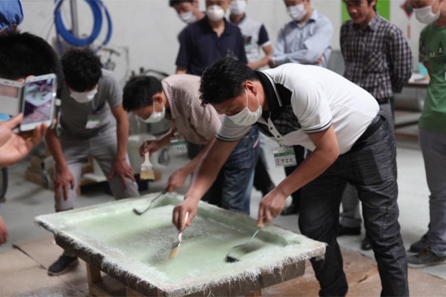 噴涂完成后，用輥筒壓實玻纖